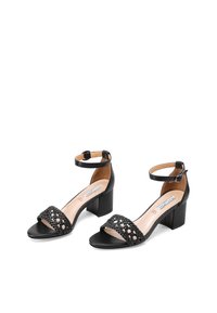 Sandali neri con tacco, dotati di cinturino alla caviglia, con un upper intrecciato, dettagli in pelle liscia e un tacco a blocco per stabilità.