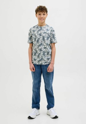 Lys grå t-shirt med et hvidt blomstermønster, parret med blå jeans og hvide sneakers. Designet er afslappet med korte ærmer.