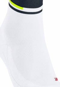 Biała skarpetka sportowa o prążkowanym wzorze, z czarnymi i neonowo-zielonymi akcentami na górze oraz czerwoną logo z boku.