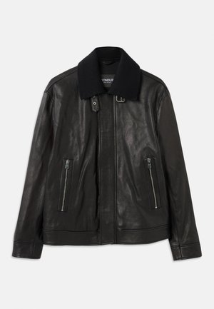 Zwarte leren jas met geribbelde gebreide kraag, ritszakken aan beide zijkanten en gespsluiting bij de hals, plat gelegd op een witte achtergrond.