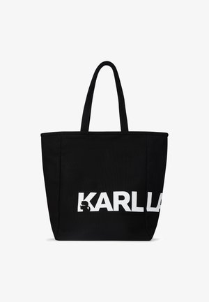 Sac fourre-tout noir en tissu durable, présentant le texte blanc "KARL" et un logo en silhouette. Deux poignées solides pour un transport facile.