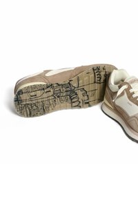 Beige Wildledersneaker mit weißen Akzenten, strukturiertem Sohlenprofil mit einem schwarzen Linienmuster und gepolsterter beige Zunge mit Logodetails.