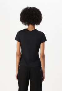 Sort kortærmet t-shirt med rund halsudskæring, glat tekstur, tætsiddende design og minimal dekoration. Stoffet ser let og strækbart ud.