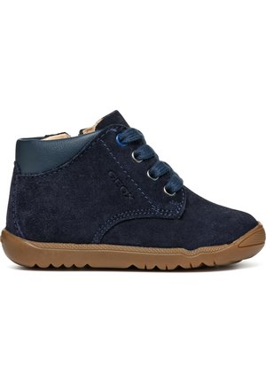 Bottines en daim bleu marine avec une tige en cuir bleu marine lisse, bout arrondi, semelle en caoutchouc et lacets bleus. Présente le logo Geox sur le côté.