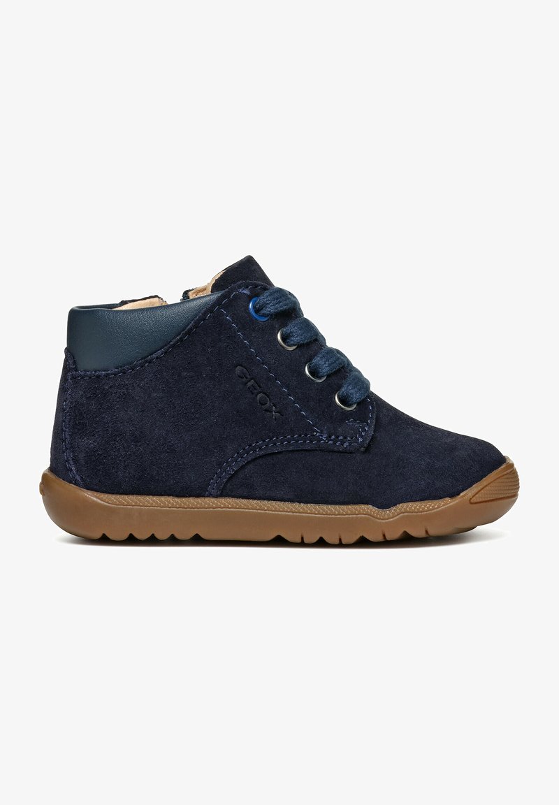 Stivali ankle in suede blu navy con tomaia in pelle liscia blu navy, punta tonda, suola in gomma e lacci blu. Presentano il marchio Geox sul lato.