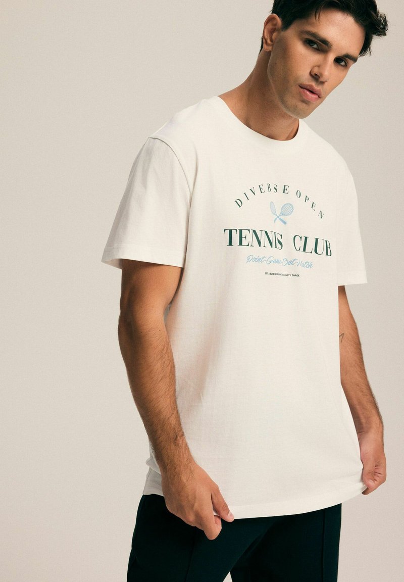 Biała bawełniana koszulka z nadrukiem "Tennis Club" w zielonym i niebieskim kolorze, krótki rękaw, okrągły dekolt, luźny krój i gładka faktura.