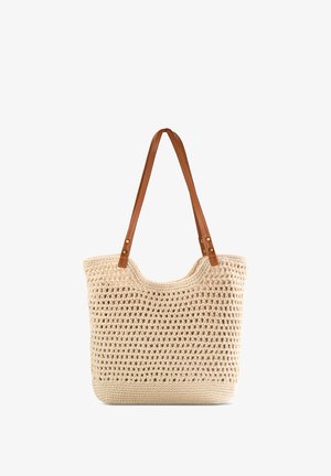 Torebka plażowa z plecionego słomy w kolorze kremowym z dwoma brązowymi skórzanymi ramiączkami oraz złotymi akcentami. Otwarte górne zapięcie z przestronnym wnętrzem.
