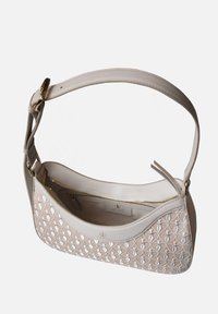 Beige Lederhandtasche mit kompliziertem weißen Stickmuster, glatter Textur, verstellbarem Tragegurt und goldfarbenen Hardware-Akzenten.