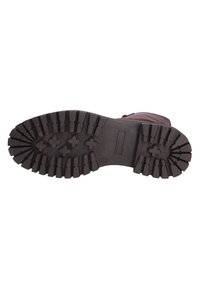 Black rubber boot sole with deep treads, featuring a textured surface and a flat heel. The design includes a central groove and cross patterns.