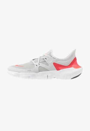 Chaussure de sport gris clair et blanc avec des accents corail rose, tige en mesh, semelle flexible et design à lacets, vue latérale.