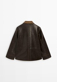 Brązowa skórzana kurtka z beżowym kołnierzem z sztruksu, charakteryzująca się luźnym krojem, długimi rękawami oraz kontrastowymi detalami w szwach.