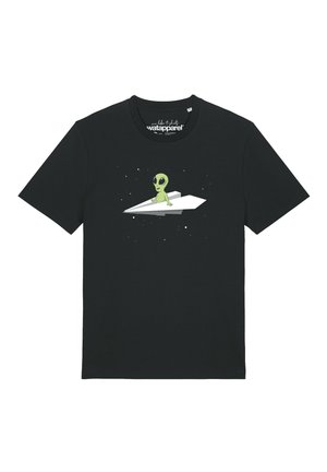 T-shirt noir avec un graphique d'un petit alien vert assis sur un avion en papier blanc sur un fond spatial étoilé.