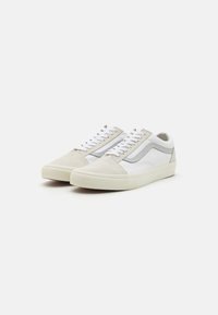 Adidași albi și gri cu superior din suede și piele, vârf rotunjit, închidere cu șireturi plate, dungi texturate pe lateral și talpă din cauciuc.