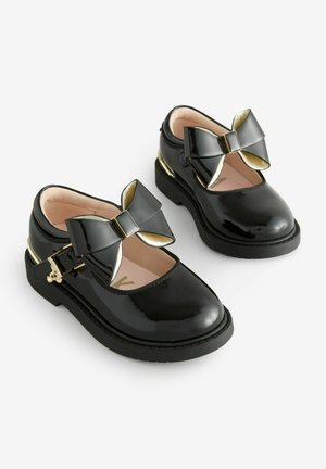 Scarpe Mary Jane in vernice nera con un brillante fiocco nero e accenti dorati. Presentano una punta arrotondata e un interno imbottito.