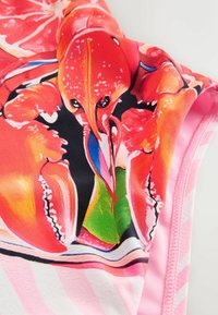 Tessuto dai colori vivaci con una stampa dettagliata di aragoste in rosso e blu, su uno sfondo nero con accenti a strisce rosa.