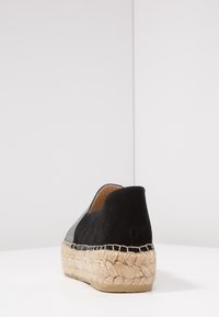 Svart och grå mocka espadrille med vävd jute-sula och en texturerad yta; låg baktill design och slät innerfodring.