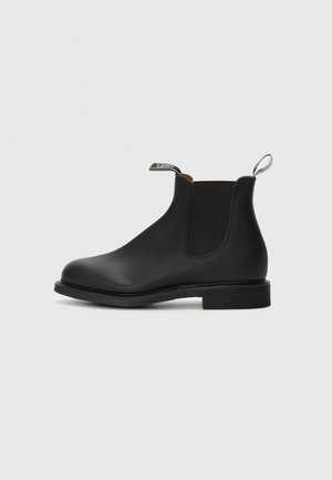 Black leather Chelsea boot with elastic side panels, rounded toe, and pull tab. Features a low block heel and smooth texture.