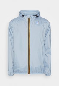 Giacca leggera azzurro chiaro con cappuccio, dotata di zip frontale con strisce gialle e arancioni, polsini elasticizzati e un logo sul petto.
