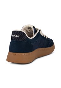 Sneaker blu navy con tomaia in suede e mesh, lacci crema e suola in gomma. Presenta un pannello posteriore testurizzato con il marchio "WODEN".