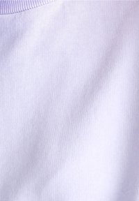 Gros plan sur une texture de tissu côtelé violet clair avec des plis subtils et un bord côtelé horizontal en haut.