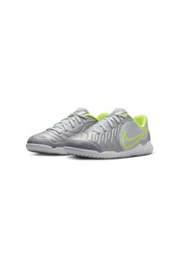 Zapatos deportivos grises con una parte superior sintética texturizada, acentos en verde neón y una suela de goma blanca. Presentan un sistema de cordones tradicional y una punta redonda.