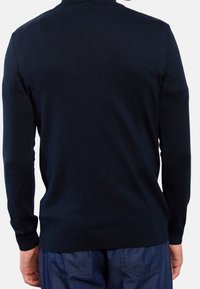 Maglione a maglia blu navy con colletto a giro e maniche lunghe. Presenta una texture liscia e polsini e orlo a coste, mostrato da dietro.