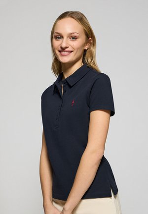 Navy polo shirt in cotton blend, featuring a three-button placket, ribbed collar, and a red logo. Side slits at the hem for ease of movement.