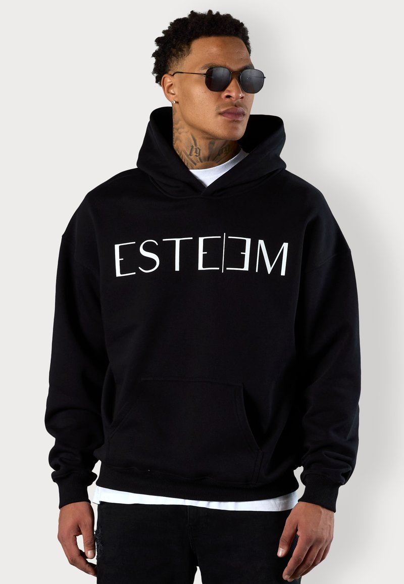 Hoodie noir avec un texte blanc en gras "ESTEEM" sur le devant, une poche kangourou et un capuchon avec cordon de serrage. Tissu lisse avec une coupe décontractée.