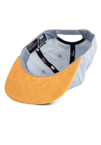 Denim cap with a light blue body and a soft, tan suede visor. Inside features a black lining and branding labels. Visor is stitched.