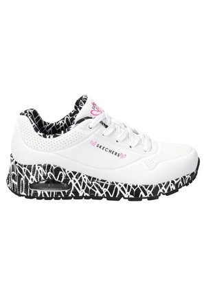Hvid Skechers sneaker med sort og hvid graffiti-agtig sål, perforerede detaljer, lyserøde hjerte-accenter og mønstret sort-hvidt inderfor.