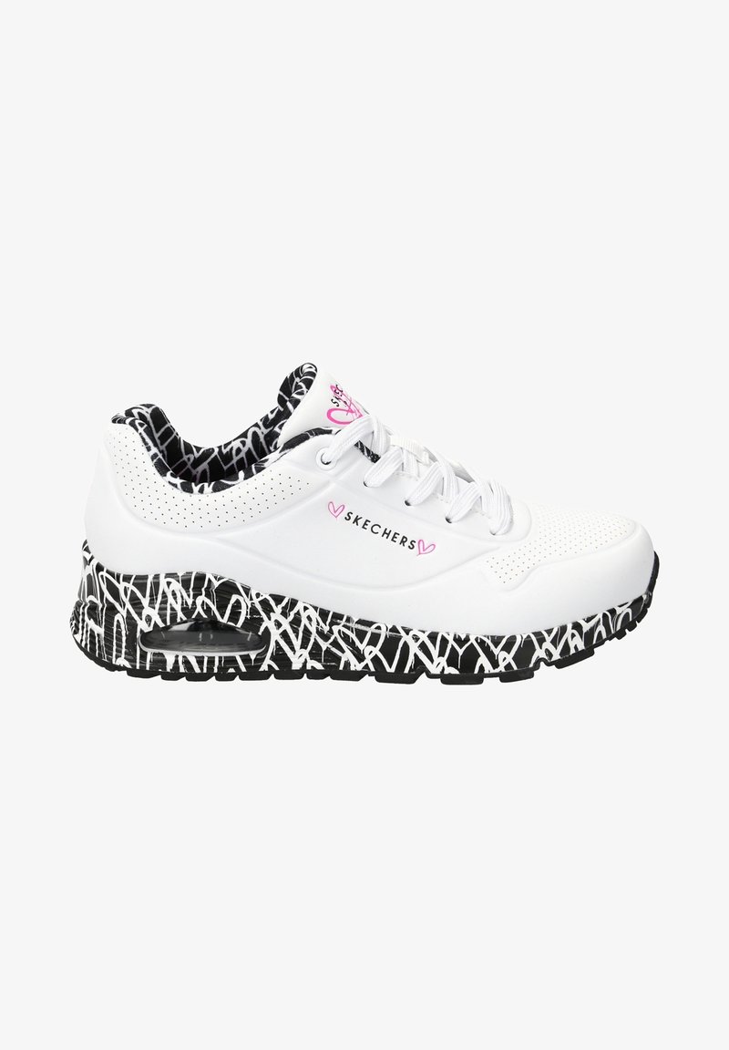 Baskets blanches Skechers avec semelle effet graffiti noire et blanche, détails perforés, accents en forme de cœur rose et doublure intérieure à motif noir et blanc.