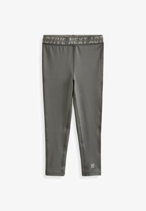 Grå aktive leggings med en bred talje, der har teksten "ACTIVE NEXT ACT". Lavet af strækbart materiale med flade sømme og logodetalje.