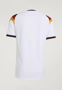 T-shirt de sport blanc à manches courtes avec des blocs de couleurs noir, rouge et jaune sur les épaules et un liseré noir sur les bords des manches et le col.