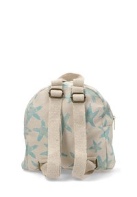 Mochila de lona en beige con patrón de pájaros azules, que cuenta con dos correas para los hombros, un asa superior y un compartimento con cremallera.