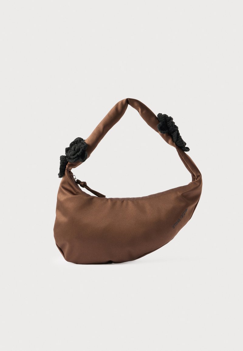 Καφέ τσάντα χειρός σε σχήμα ημισελήνου με επενδεδυμένη λαβή που διαθέτει μαύρες υφασμάτινες υφές σε κάθε πλευρά και κλείσιμο με φερμουάρ.