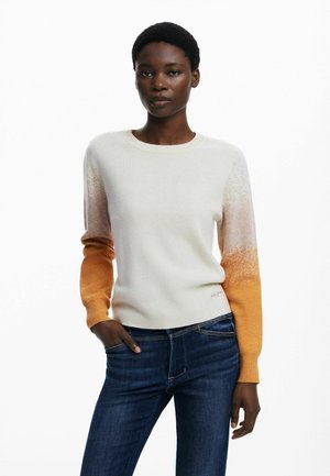 Trøje i creme med gradient orange strikkede ærmer; glat tekstur, rund halsudskæring, subtilt mønster der falmer fra lys til mørk.