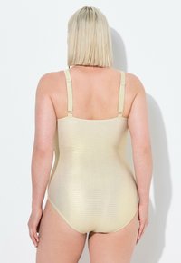 Maillot de bain une pièce doré métallique avec des motifs ondulés texturés, des bretelles ajustables et une finition lisse, vu de l'arrière.