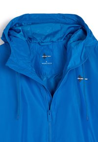 Jasnoniebieska kurtka z zamkiem z przodu, regulowanym kapturem i detalem logo. Gładki, syntetyczny materiał o subtelnym połysku i podszewce wewnętrznej.