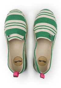 Une paire de chaussures slip-on rayées vertes et beiges avec des onglets de talon roses et des semelles "flip flop", vue de dessus sur un fond blanc.