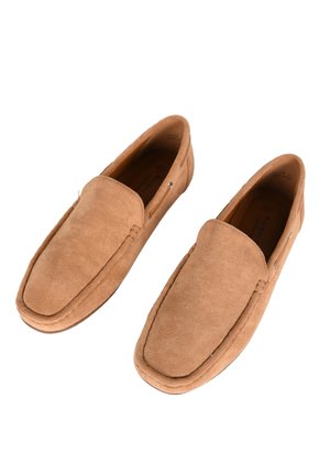 Mocassini in suede marrone con punta arrotondata, texture liscia e dettagli cuciti. Presentano un design slip-on confortevole e un sottile logo del marchio.