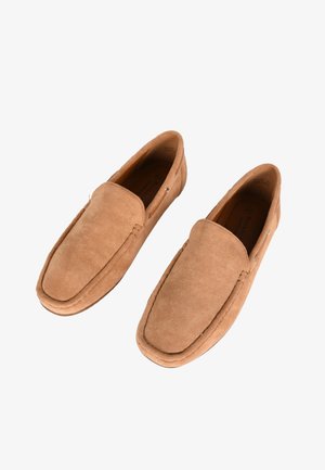 Mocassini in suede marrone con punta arrotondata, texture liscia e dettagli cuciti. Presentano un design slip-on confortevole e un sottile logo del marchio.