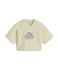 Cropped yellow cotton t-shirt with short sleeves. Features a floral graphic with birds at the center and text below in a decorative font.