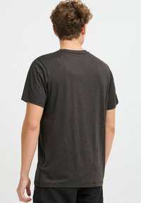 Camiseta corta de manga con cuello redondo en gris oscuro, hecha de una tela suave, con una textura lisa y un diseño simple y minimalista.