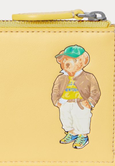 Yellow leather wallet featuring a cartoon bear in a green cap, brown jacket, and yellow shirt with blue text, standing in white pants and blue sneakers.