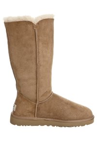 Beżowy zamszowy kozaki za kolano z miękką, pluszową wyściółką wewnętrzną. Posiadają zaokrąglony nosek i grubą, teksturowaną gumową podeszwę.