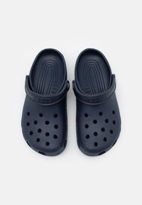 Temno modri Crocs natikači z luknjičasto zasnovo za zračnost, fleksibilnim materialom in trakom na zadnjem delu za varen oprijem.