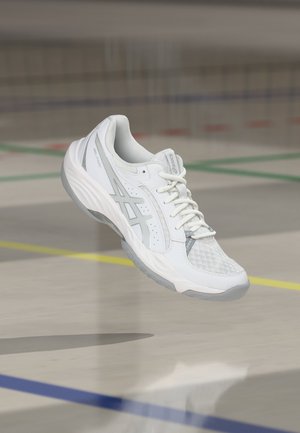 Weißer und grauer ASICS Sportschuh schwebt über dem Hallenboden mit bunten Begrenzungslinien im Hintergrund.