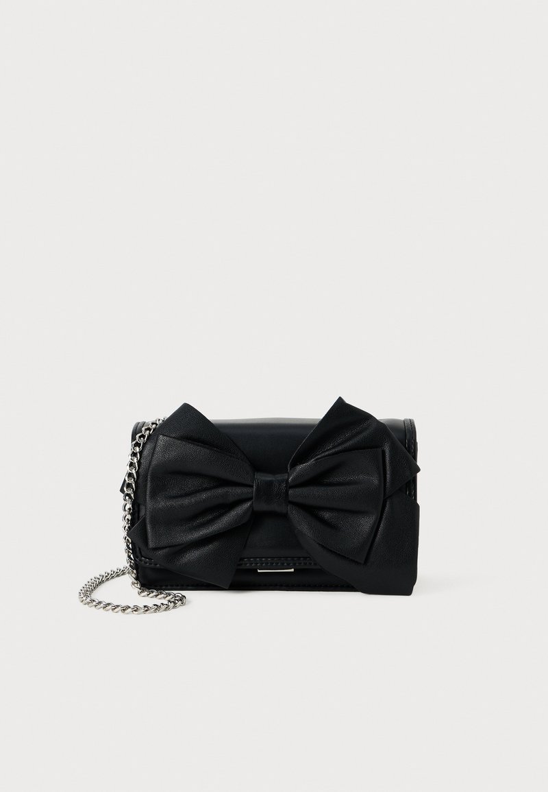 Fekete bőr clutch, nagy masni díszítéssel, ezüst láncos pánttal, téglalap alakú, sima textúrával és cipzáros záródással.