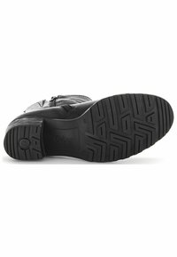 Bota de cuero negra con un acabado texturizado, suela de goma con un grabado de patrón y un zipper lateral para facilitar el uso.