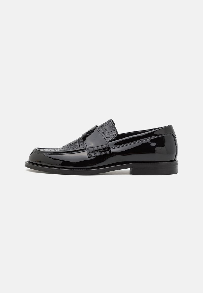 Mustad musta läikiva nahaga loafers, millel on tekstureeritud ülemine, ümar nina ja lame tall, millel on õrnad tikandid.
